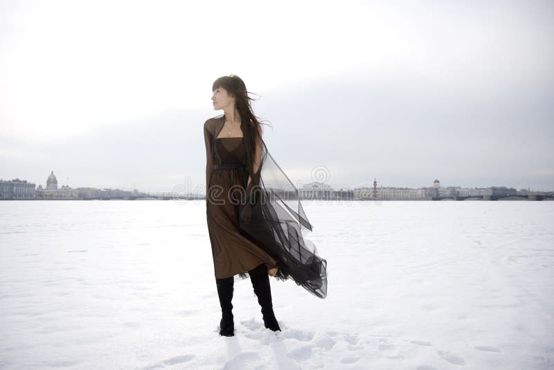 Menina de encontro a um fundo da neve e da cidade. imagens de stock royalty free Menina de encontro a um fundo da neve e da cidade. imagens de stock royalty free