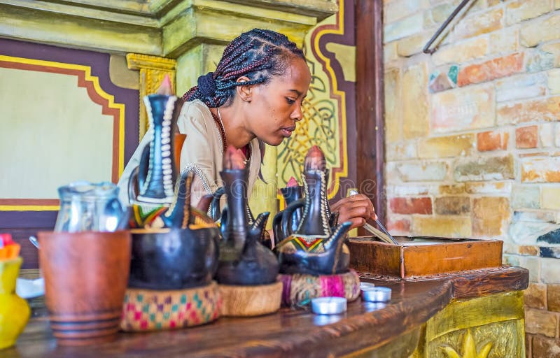 KIEV, UKRAINE - JUNE 4, 2017: The young EthiopianTigrayan girl at work - she roasts coffee beans for the traditional coffee ceremony, on June 4 in Kiev. KIEV, UKRAINE - JUNE 4, 2017: The young EthiopianTigrayan girl at work - she roasts coffee beans for the traditional coffee ceremony, on June 4 in Kiev.