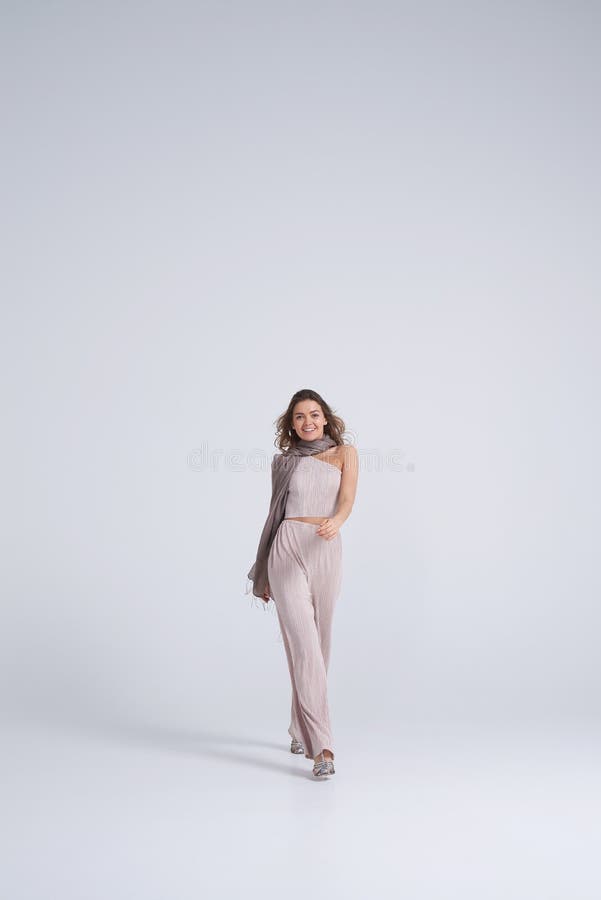 Menina de sorriso na roupa à moda que anda para a câmera fotos de stock royalty free Menina de sorriso na roupa à moda que anda para a câmera fotos de stock royalty free