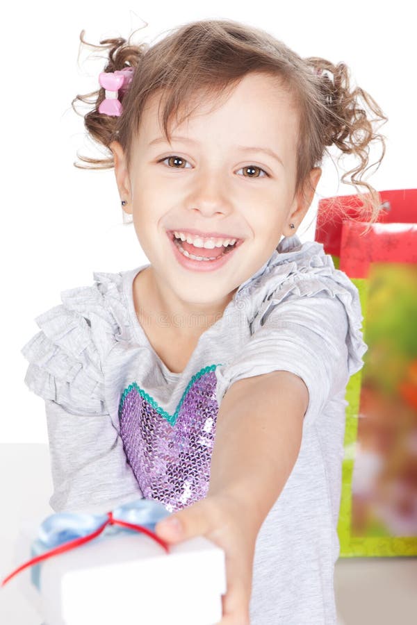 Menina de sorriso que dá lhe um presente no estúdio imagem de stock royalty free Menina de sorriso que dá lhe um presente no estúdio imagem de stock royalty free