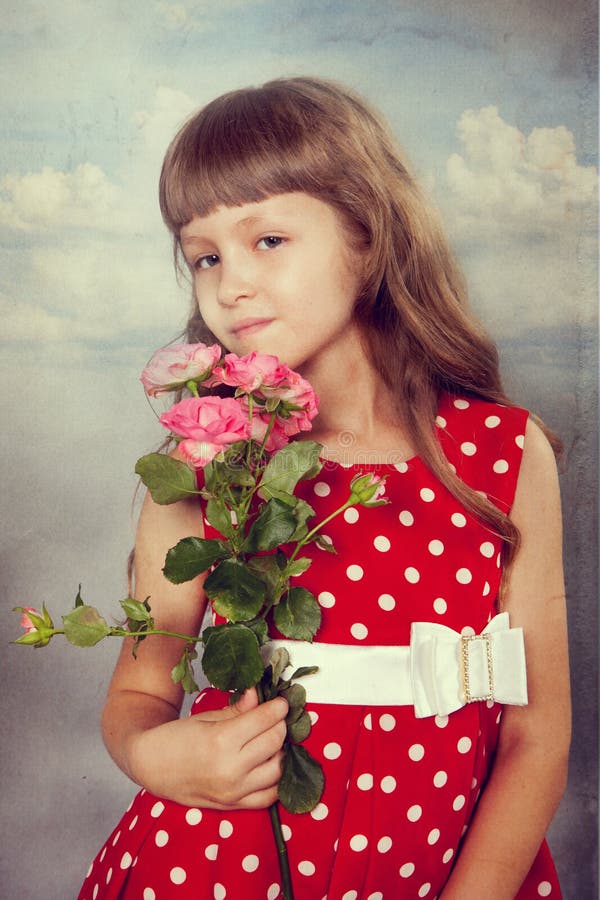 Menina de sorriso que guarda flores imagem de stock Menina de sorriso que guarda flores imagem de stock
