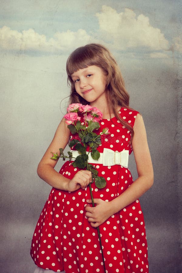 Menina de sorriso que guarda flores fotos de stock royalty free Menina de sorriso que guarda flores fotos de stock royalty free