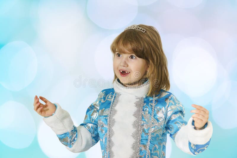 A menina desdentado feliz no terno azul da donzela da neve acenou suas mãos na surpresa fotografia de stock A menina desdentado feliz no terno azul da donzela da neve acenou suas mãos na surpresa fotografia de stock