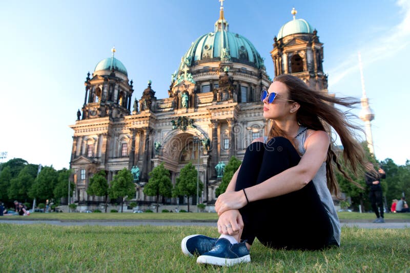A menina despreocupada relaxa em Alemanha na catedral de Berlim a menina bonita relaxa na grama do verão perto da catedral de Ber foto de stock A menina despreocupada relaxa em Alemanha na catedral de Berlim a menina bonita relaxa na grama do verão perto da catedral de Ber foto de stock