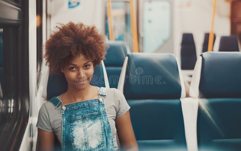 Menina do Afro em nivelar o trem suburbano vazio fotografia de stock Menina do Afro em nivelar o trem suburbano vazio fotografia de stock