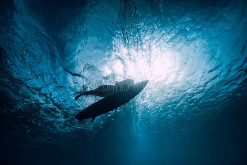 Surfer with surfboard dive underwater with under ocean wave. Surfer with surfboard dive underwater with under ocean wave