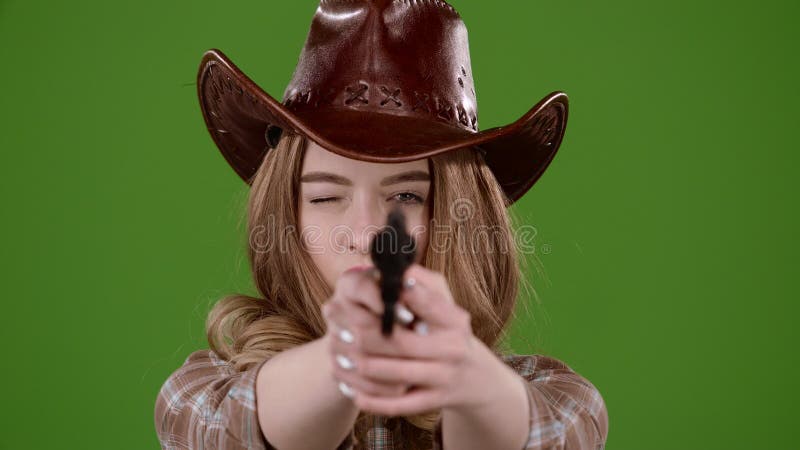 A menina do xerife guarda um revólver em suas mãos e em visar o bandido Tela verde Movimento lento