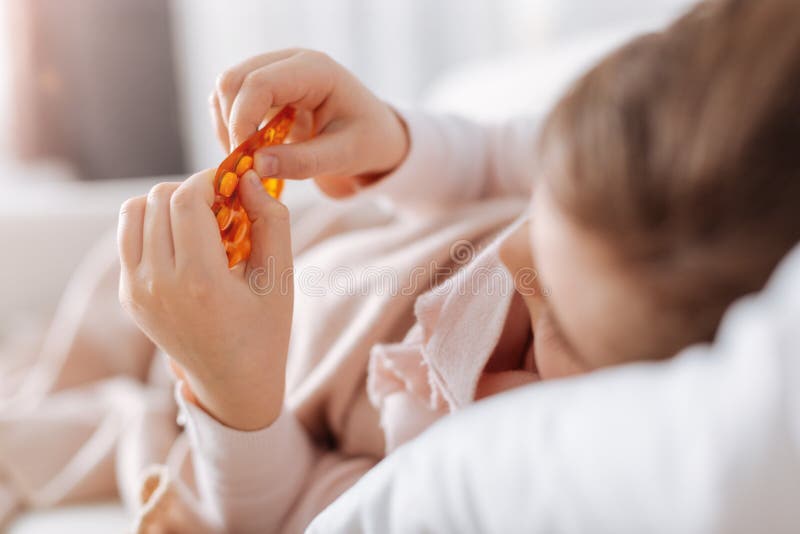 Menina doente a tomar comprimidos fotografia de stock