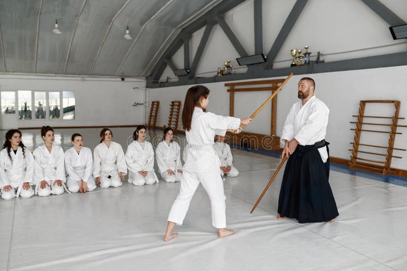 Menina E Mestre Aikido Lutando Com Espada De Madeira Durante a