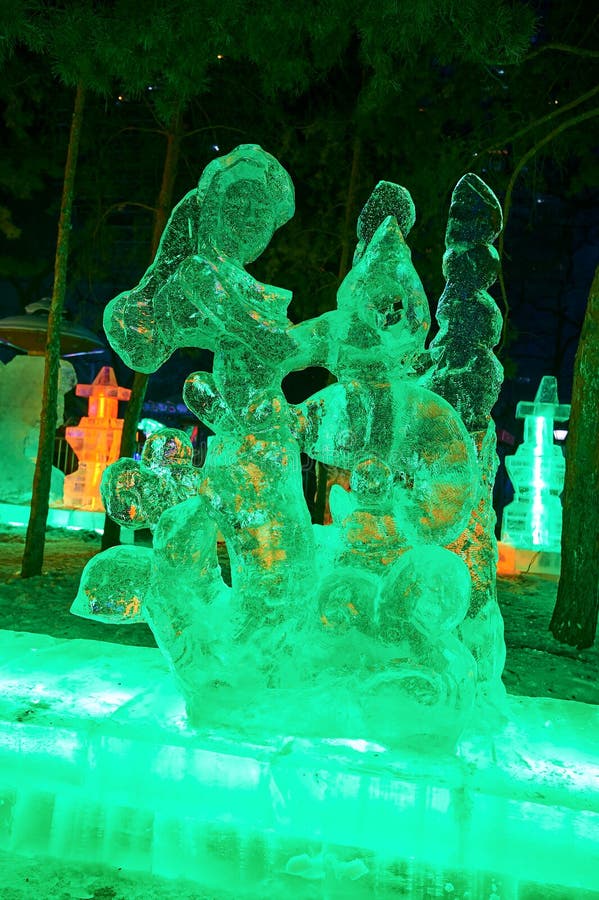 A menina e o animale de lâmpadas do gelo no nightscape do parque imagem de stock