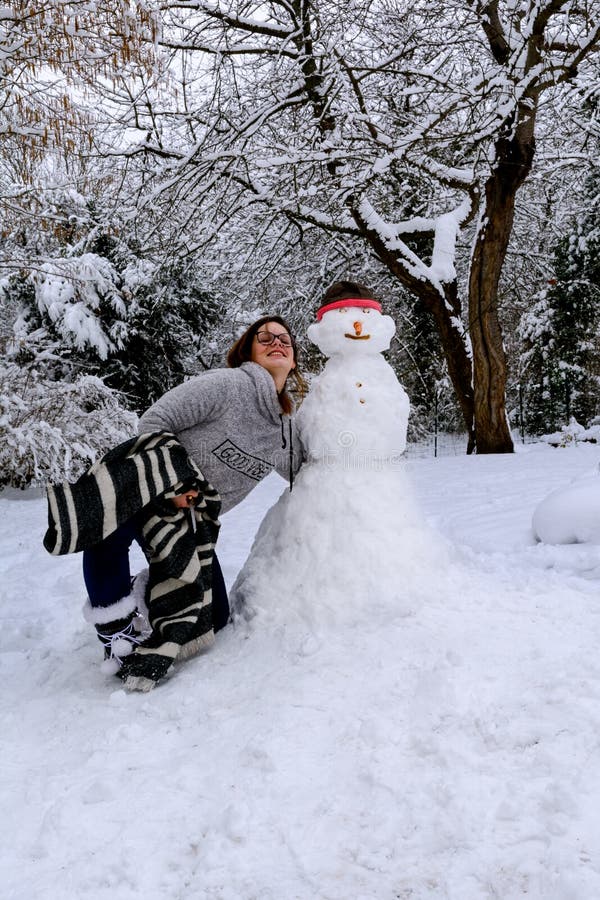 A menina e o boneco de neve fotos de stock A menina e o boneco de neve fotos de stock