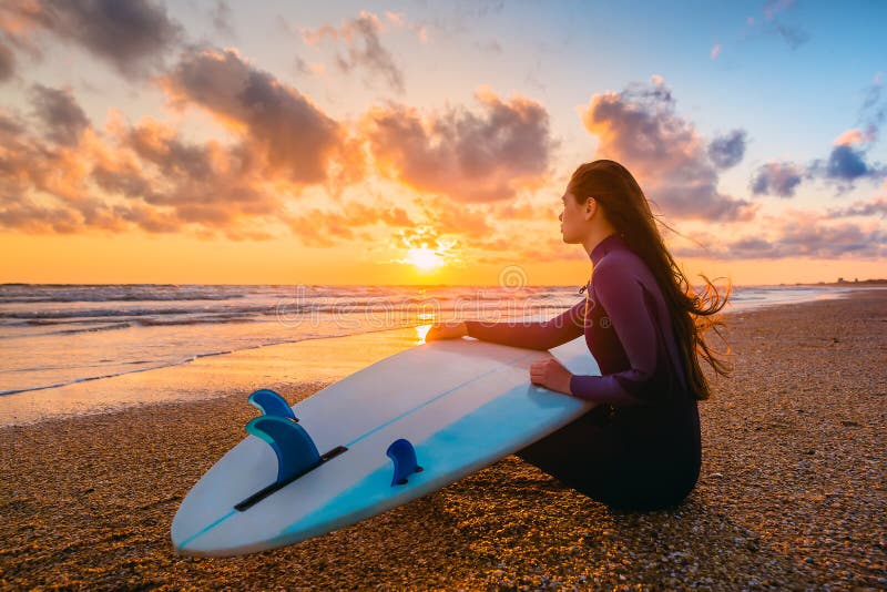 Surf girl and ocean. Beautiful young woman surfer girl with surfboard on a beach at sunset. Surf girl and ocean. Beautiful young woman surfer girl with surfboard on a beach at sunset.