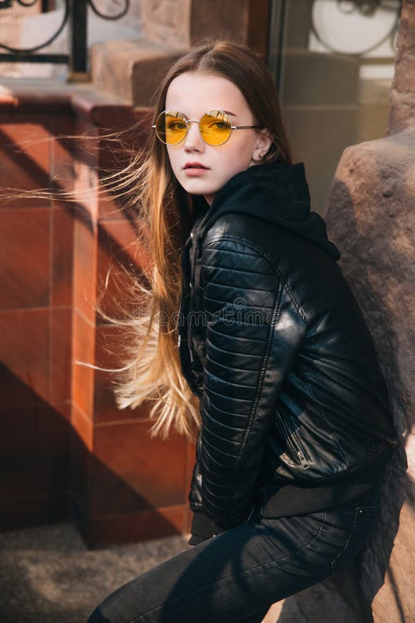 Menina elegante bonita com cabelo louro longo em óculos de sol amarelos na cidade, criança do adolescente da forma da rua, imagens de stock Menina elegante bonita com cabelo louro longo em óculos de sol amarelos na cidade, criança do adolescente da forma da rua, imagens de stock