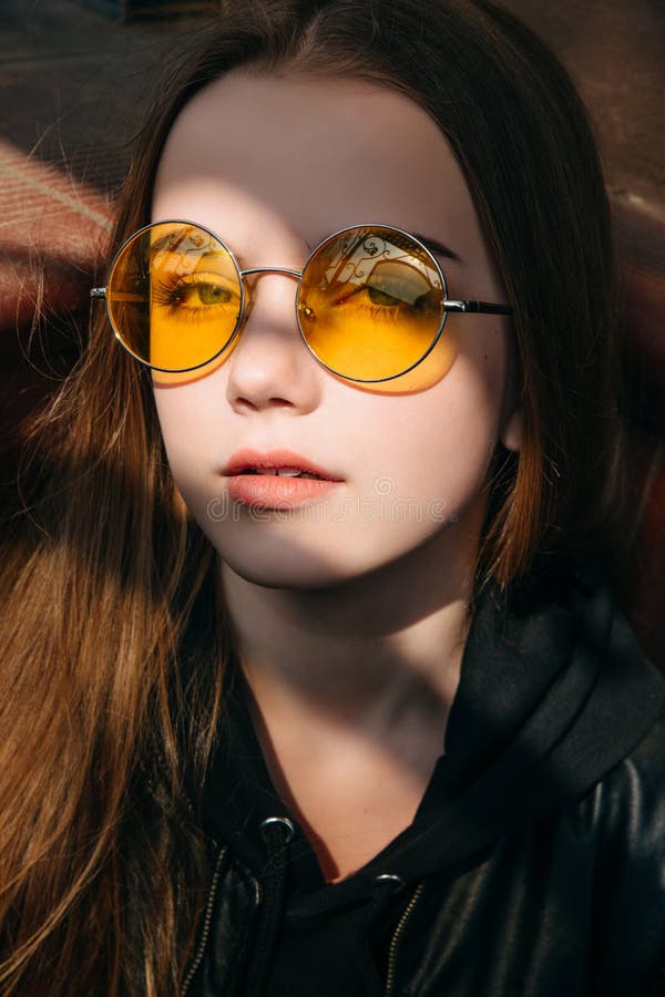 Menina elegante bonita com cabelo louro longo em óculos de sol amarelos na cidade, criança do adolescente da forma da rua, fotos de stock Menina elegante bonita com cabelo louro longo em óculos de sol amarelos na cidade, criança do adolescente da forma da rua, fotos de stock