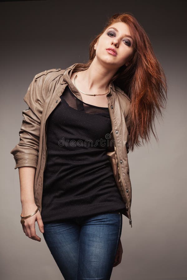 A menina em um casaco de cabedal representa o modelo imagens de stock royalty free A menina em um casaco de cabedal representa o modelo imagens de stock royalty free