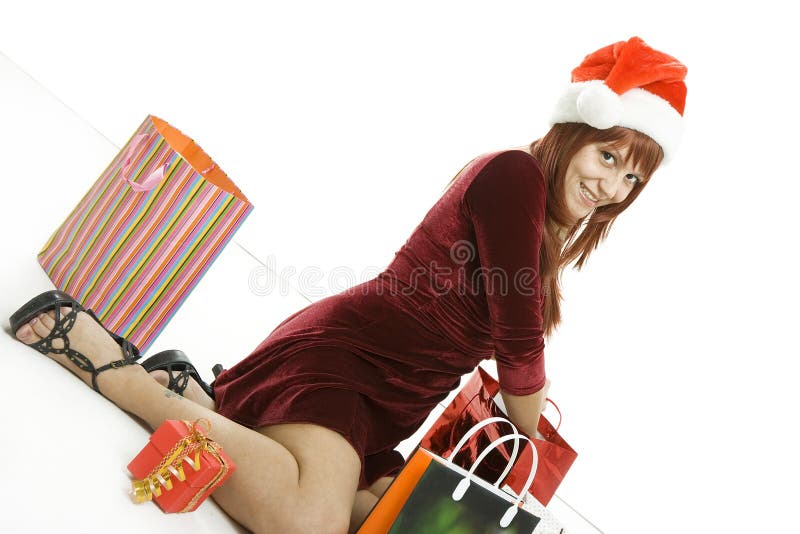A menina em um tampão do Natal com compras fotos de stock royalty free A menina em um tampão do Natal com compras fotos de stock royalty free