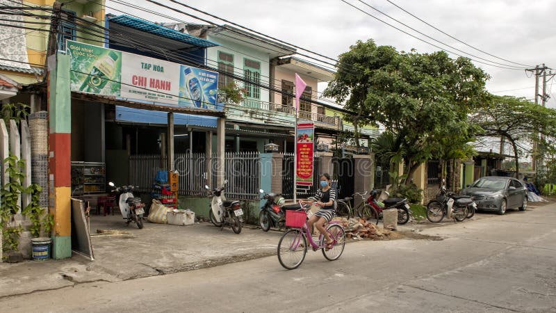 Menina em uma bicicleta que vem para baixo a rua principal da vila de cultivo de Phunong Nam em Vietname imagem de stock royalty free Menina em uma bicicleta que vem para baixo a rua principal da vila de cultivo de Phunong Nam em Vietname imagem de stock royalty free