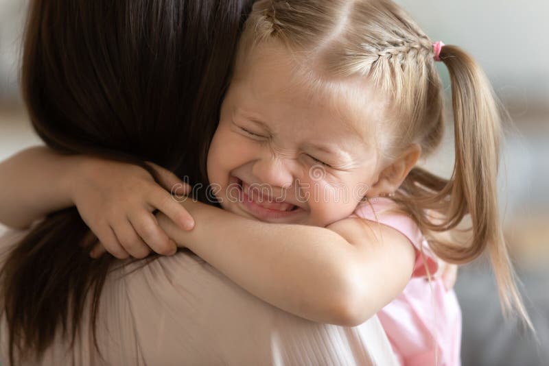 Menina engraçada sorrindo abraçando a mãe mãe adotiva