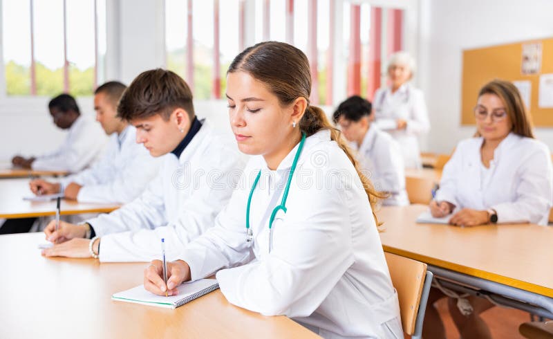 Menina estudante de medicina tomando notas durante a palestra em grupo fotos de stock royalty free