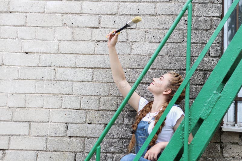 A menina faz a preparação para pintar um miradouro de superfície de madeira, cerca imagens de stock royalty free A menina faz a preparação para pintar um miradouro de superfície de madeira, cerca imagens de stock royalty free