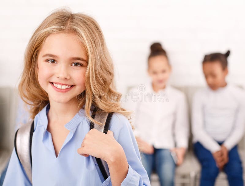 Menina feliz da escola com os colegas no fundo imagem de stock Menina feliz da escola com os colegas no fundo imagem de stock
