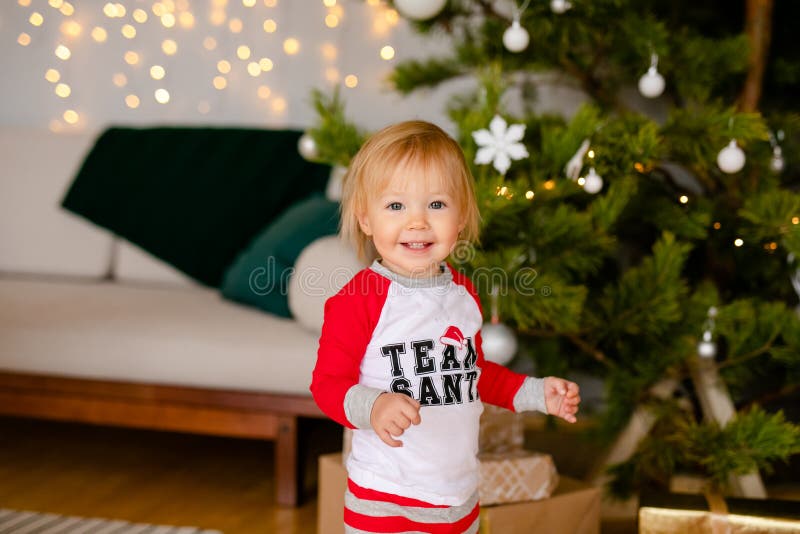 Feliz Bebê Loira Com Duas Pequenas Tranças Em Camiseta Branca E Um Kit De  Calças Jeans Sentado Sobre O Fundo Da Grama Verde Foto de Stock - Imagem de  pouco, inocência: 143643548