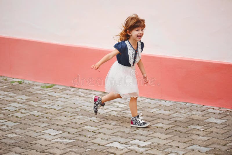 Menina feliz nova que corre afastado imagens de stock Menina feliz nova que corre afastado imagens de stock