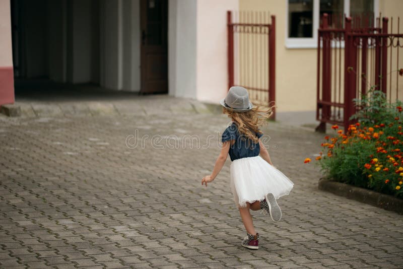 Menina feliz nova que corre afastado foto de stock royalty free Menina feliz nova que corre afastado foto de stock royalty free
