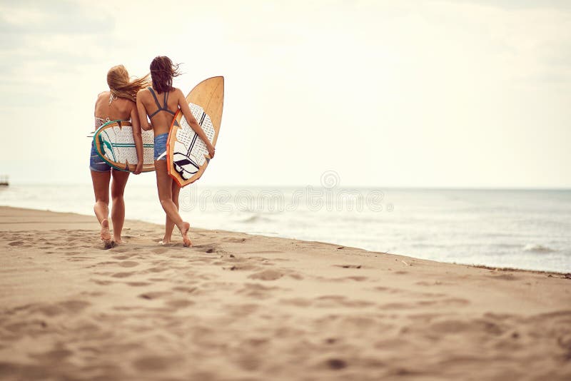 Menina feliz que anda com placa de ressaca no Sandy Beach foto de stock royalty free Menina feliz que anda com placa de ressaca no Sandy Beach foto de stock royalty free