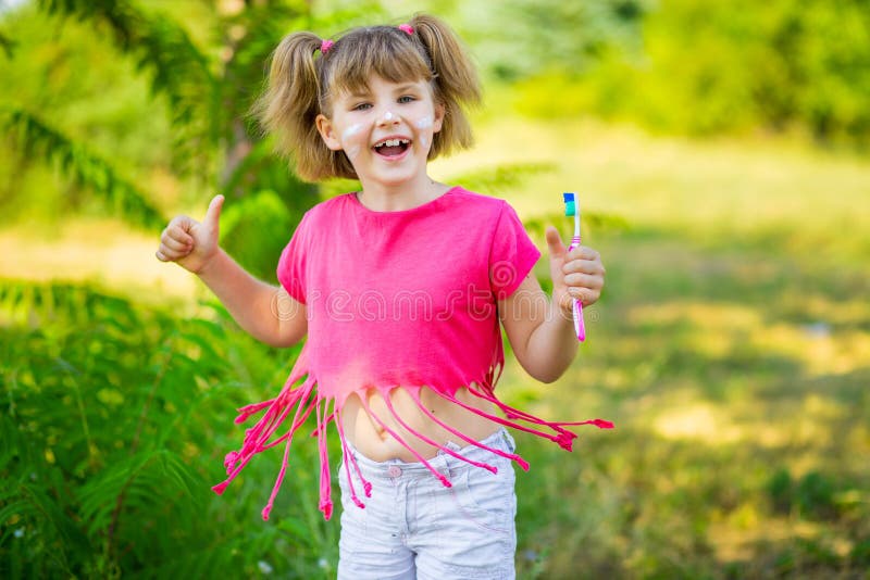 Menina feliz que escova seus dentes com polegares acima Higiene dental foto de stock Menina feliz que escova seus dentes com polegares acima Higiene dental foto de stock