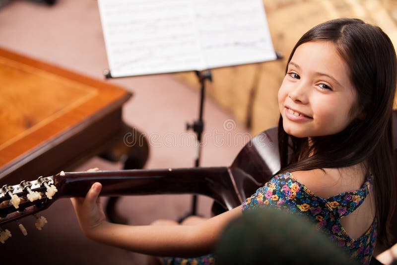 Menina feliz que joga a guitarra fotografia de stock Menina feliz que joga a guitarra fotografia de stock