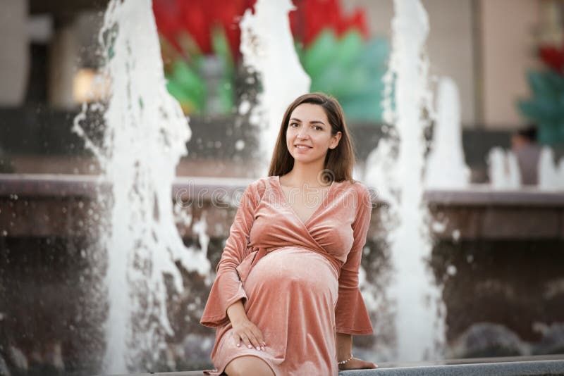 Menina grávida perto da fonte gravidez feliz e despreocupada fotos de stock Menina grávida perto da fonte gravidez feliz e despreocupada fotos de stock
