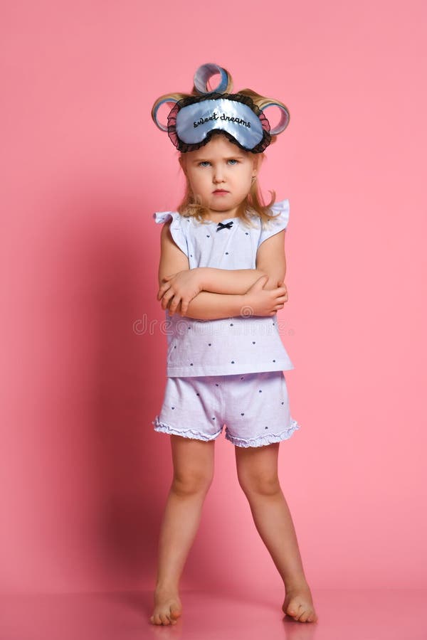 Menina irritada nos pijamas e em uma m?scara do sono, dobrou seus bra?os em uma pose em sua caixa e olhou de sobrancelhas franzid fotos de stock Menina irritada nos pijamas e em uma m?scara do sono, dobrou seus bra?os em uma pose em sua caixa e olhou de sobrancelhas franzid fotos de stock