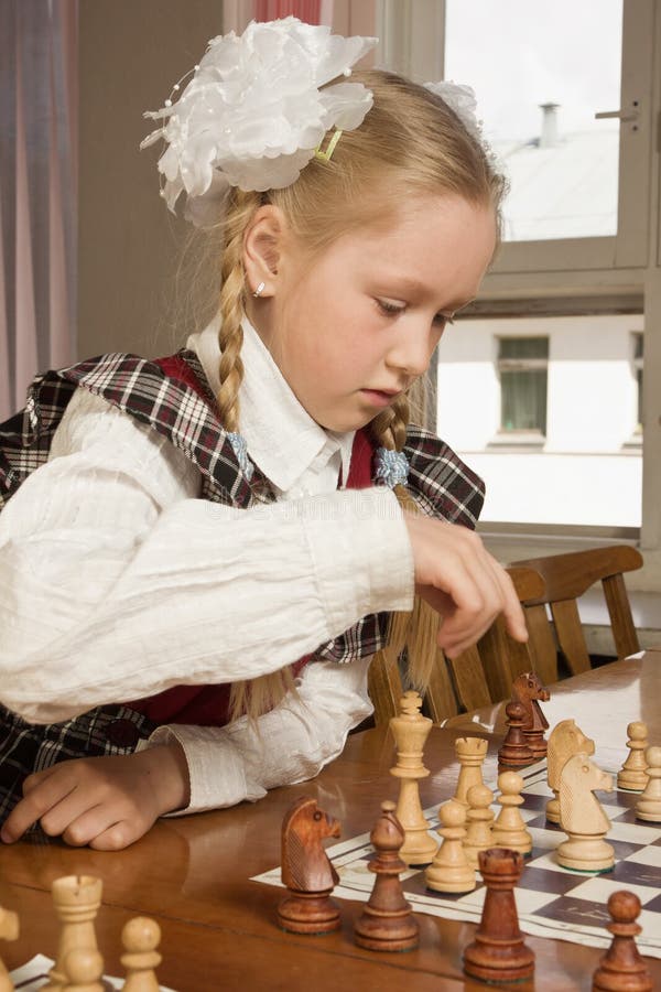 Garota Feliz Jogando Xadrez Na Sala De Aula Clara Imagem de Stock
