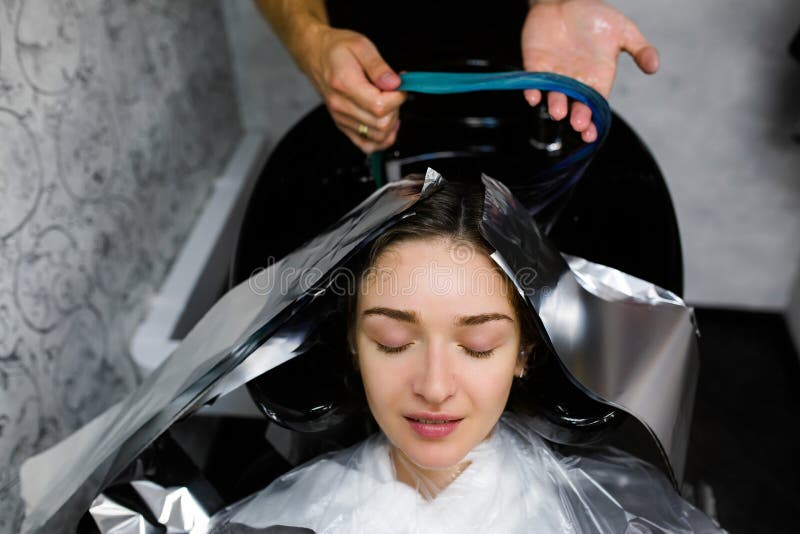 Girl wash her head in a beauty salon. Hair dying coloring, foil. Girl wash her head in a beauty salon. Hair dying coloring, foil