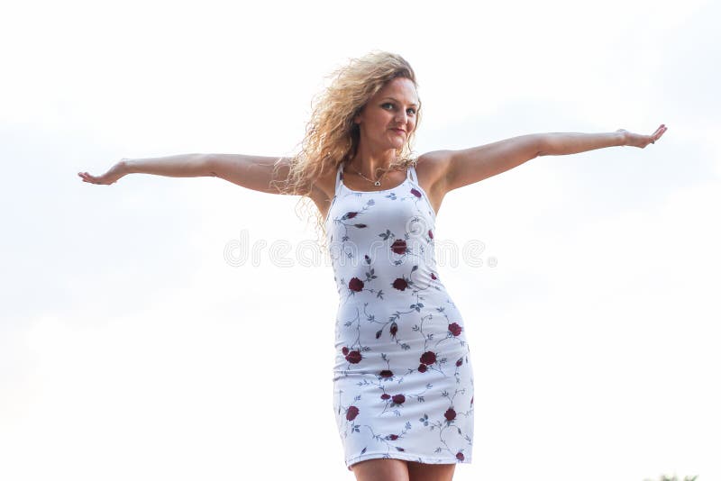 Menina loura atrativa nova que espalha seus braços imagem de stock Menina loura atrativa nova que espalha seus braços imagem de stock