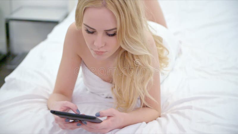 Menina loura bonita que encontra-se na cama video estoque