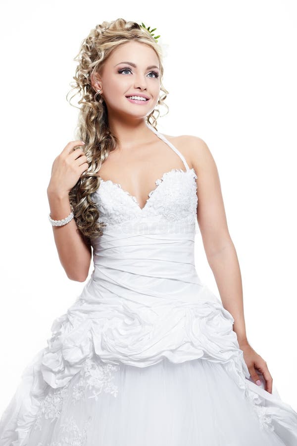 Happy smiling beautiful bride blond girl in white wedding dress with hairstyle and bright makeup on white background. Happy smiling beautiful bride blond girl in white wedding dress with hairstyle and bright makeup on white background