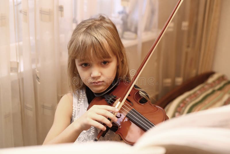 Menina loura do preteen que joga o violino fotos de stock royalty free Menina loura do preteen que joga o violino fotos de stock royalty free