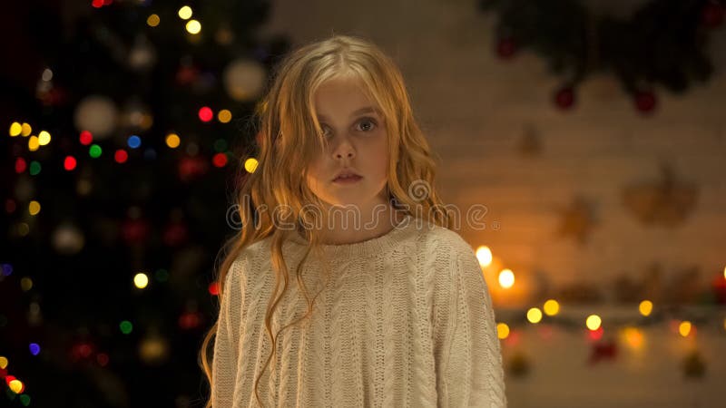 Menina loura virada que olha a câmera, anúncio social dos órfão abandonados no Natal foto de stock royalty free Menina loura virada que olha a câmera, anúncio social dos órfão abandonados no Natal foto de stock royalty free