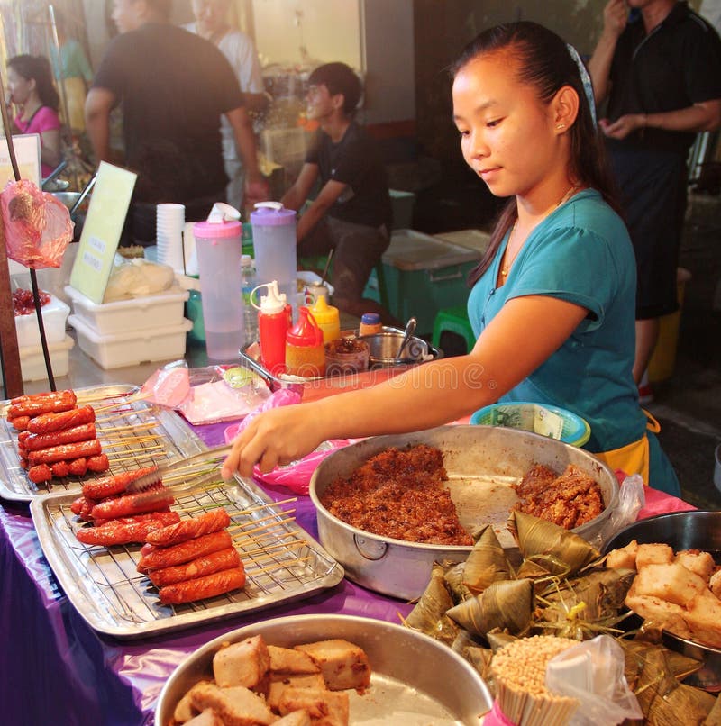 Menina malaia que vende petiscos locais no alimento da rua da noite em Malacca Malásia imagens de stock royalty free Menina malaia que vende petiscos locais no alimento da rua da noite em Malacca Malásia imagens de stock royalty free