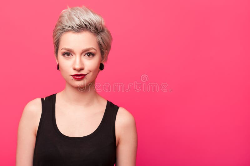 Menina modelo loura que sorri sobre o fundo cor-de-rosa fotografia de stock royalty free Menina modelo loura que sorri sobre o fundo cor-de-rosa fotografia de stock royalty free