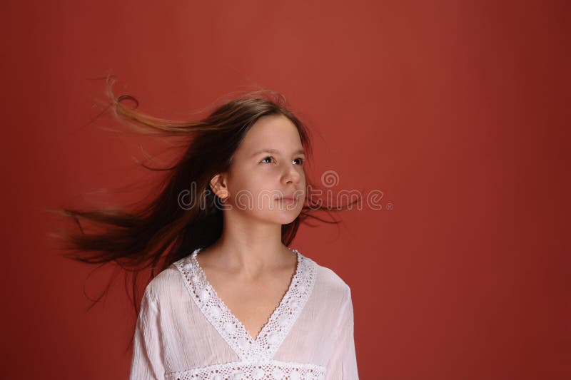 Menina num estúdio com fundo vermelho e cabelo ao vento foto de stock