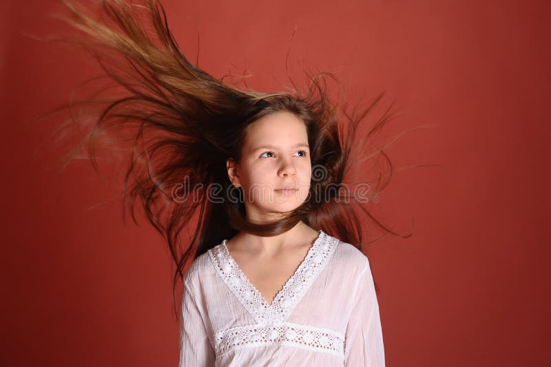 Menina num estúdio com fundo vermelho e cabelo ao vento imagens de stock royalty free