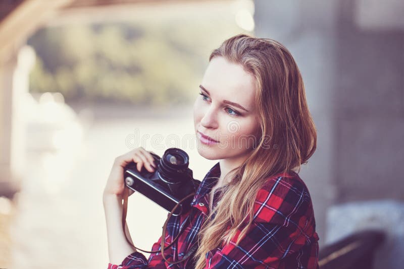 Menina no short e em uma camisa vermelha, com uma câmera retro imagem de stock Menina no short e em uma camisa vermelha, com uma câmera retro imagem de stock
