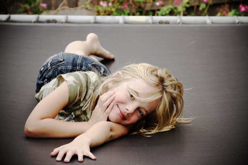 Menina no trampoline, sorrindo imagens de stock royalty free Menina no trampoline, sorrindo imagens de stock royalty free