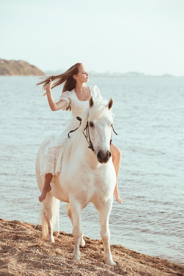 Menina no vestido branco com o cavalo na praia imagens de stock Menina no vestido branco com o cavalo na praia imagens de stock