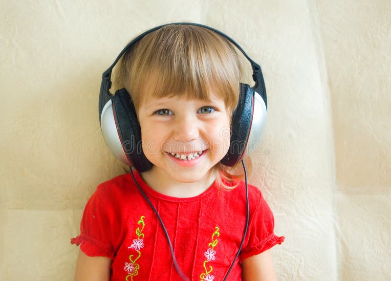 A menina nos fones de ouvido imagens de stock royalty free A menina nos fones de ouvido imagens de stock royalty free