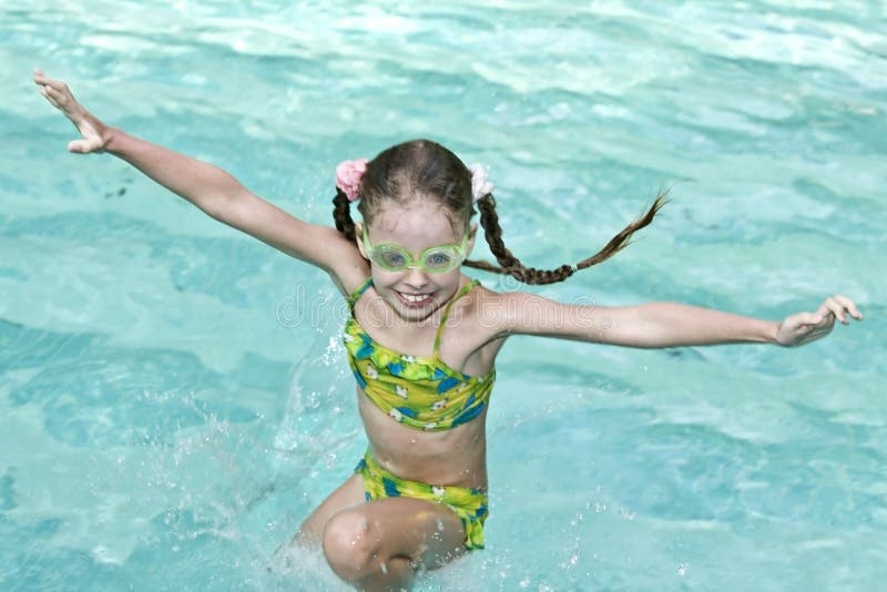 A menina nos óculos de proteção aprende o swiml. imagem de stock royalty free A menina nos óculos de proteção aprende o swiml. imagem de stock royalty free