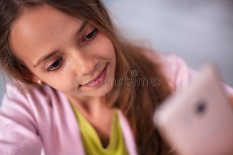 Menina nova do adolescente que toma um selfie bonito com seu telefone foto de stock royalty free Menina nova do adolescente que toma um selfie bonito com seu telefone foto de stock royalty free